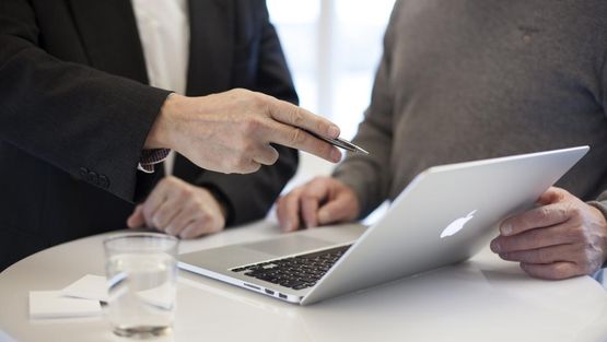 Illustrasjon - nærbilde av to personer ved en laptop